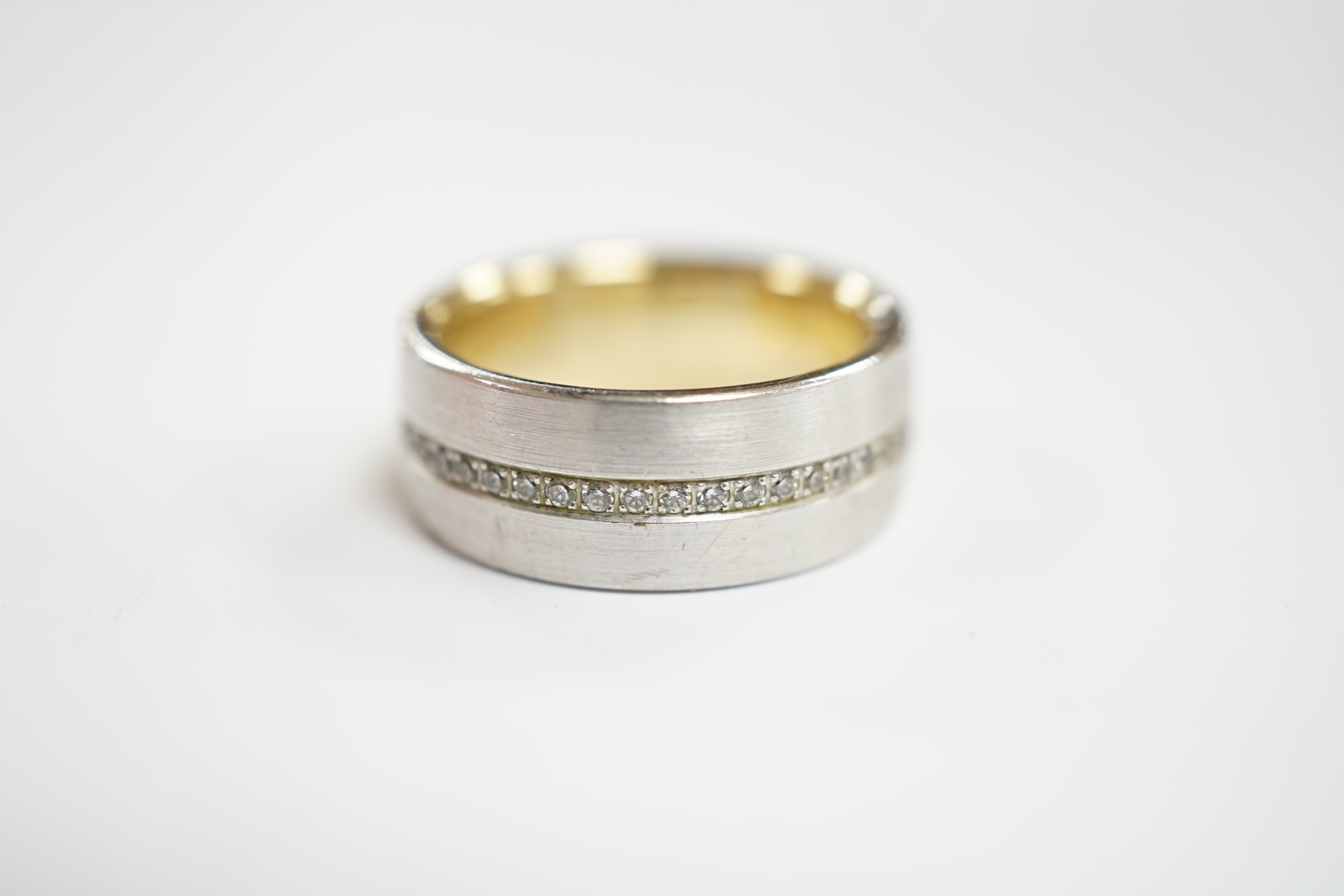 A two colour base metal band, with central row of simulated diamonds, size O.